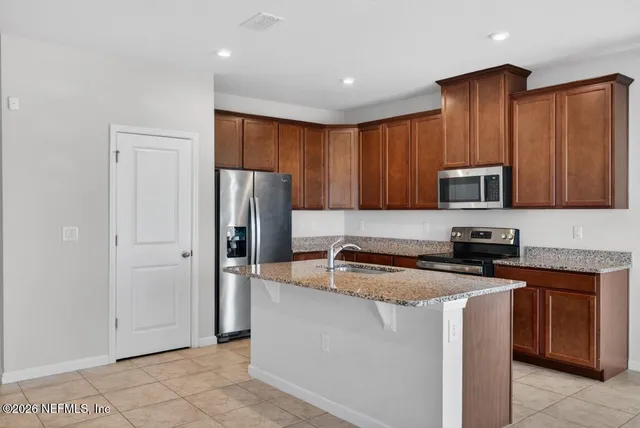 a view of a kitchen with microwave and refrigerator
