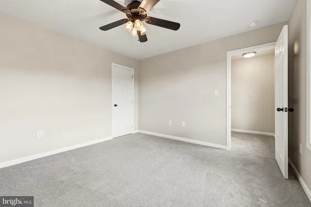 an empty room with a ceiling fan and a fan