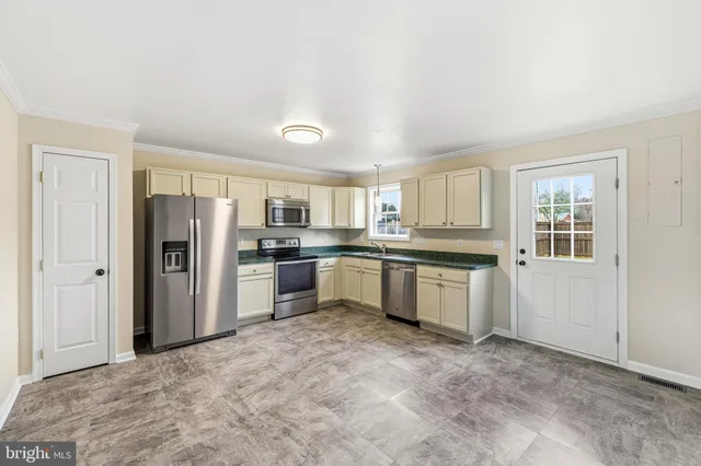 a large kitchen with refrigerator sink and cabinets