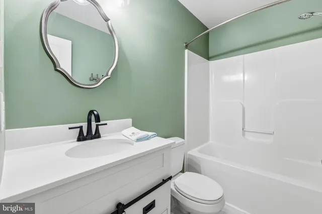 a bathroom with a sink a toilet and a mirror