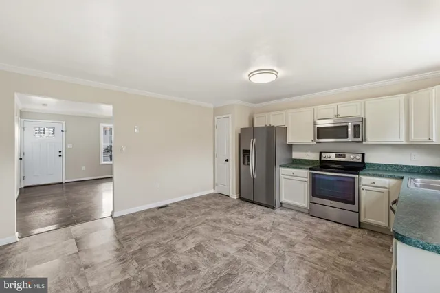 a kitchen with stainless steel appliances granite countertop a refrigerator and a stove top oven