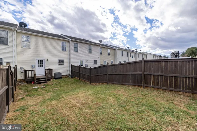 a view of a backyard with chairs and a large tree