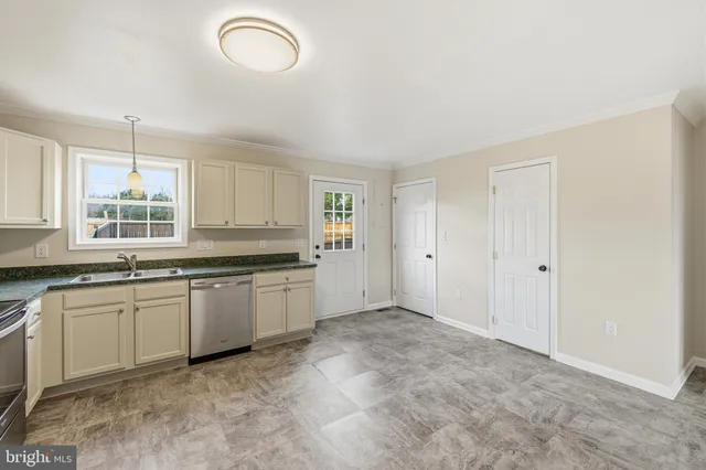 a kitchen with granite countertop a sink cabinets and window