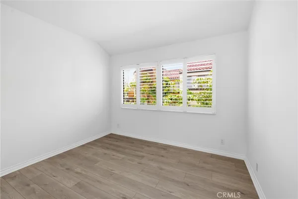 an empty room with wooden floor and a window