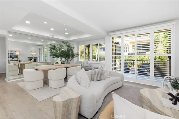 a living room with couches and a large window with garden view