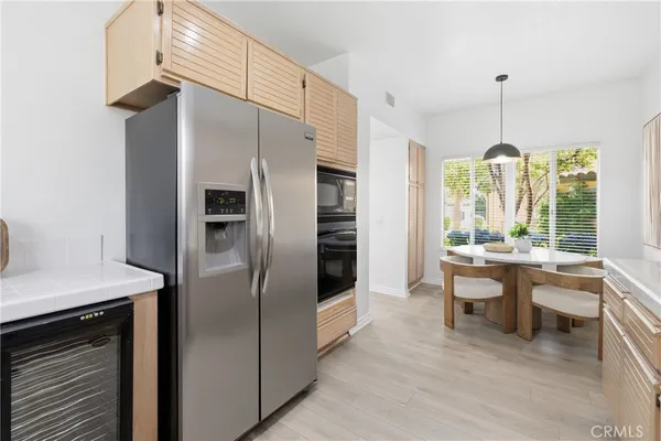 a kitchen with granite countertop a refrigerator and a stove top oven