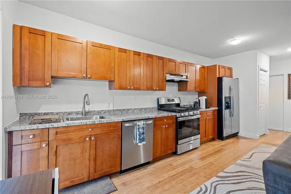 a kitchen with stainless steel appliances granite countertop a stove a sink dishwasher and a refrigerator