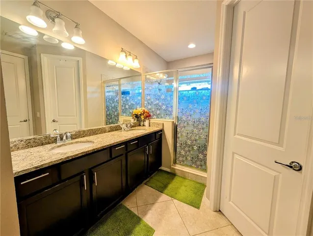 a bathroom with a double vanity sink mirror and shower