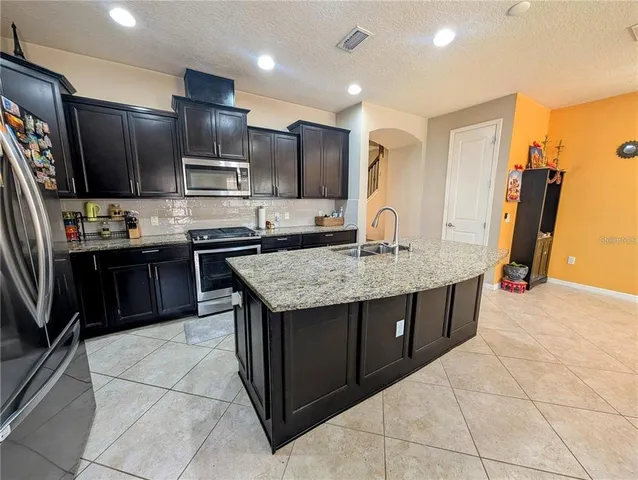 a kitchen with stainless steel appliances granite countertop a sink stove and refrigerator