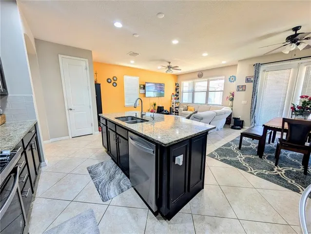 a kitchen with stainless steel appliances granite countertop a table and chairs