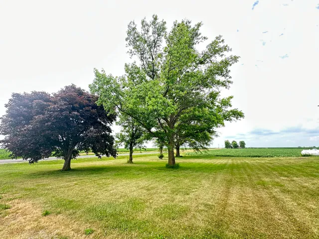 a view of an empty room with kitchen and window