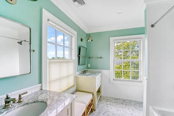 a bathroom with a granite countertop tub sink and mirror
