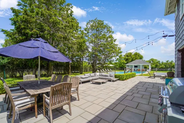 a patio with a table and chairs under an umbrella