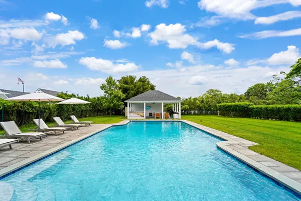 a view of a house with pool and a yard