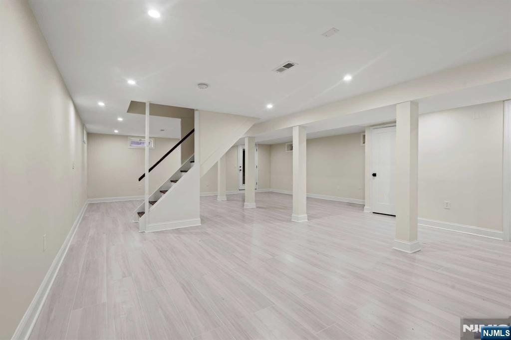 238 Springfield Avenue, Unit 1 Rutherford, NJ 07070 - Photo 13 of 33 a view of an empty room with wooden floor and stairs