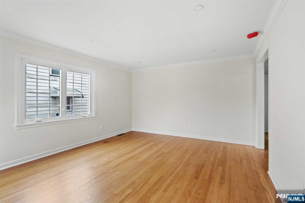 238 Springfield Avenue, Unit 1 Rutherford, NJ 07070 - Photo 3 of 33 a view of an empty room with wooden floor and a window