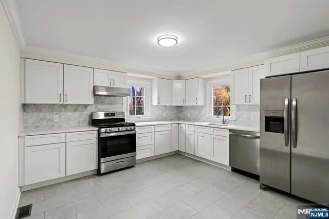 a kitchen with a refrigerator stove top oven and sink