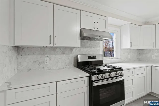 a kitchen with white cabinets and appliances