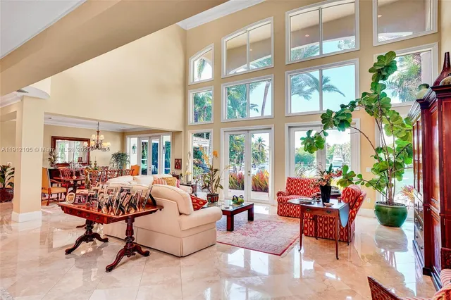 a living room with furniture a flat screen tv and a floor to ceiling window
