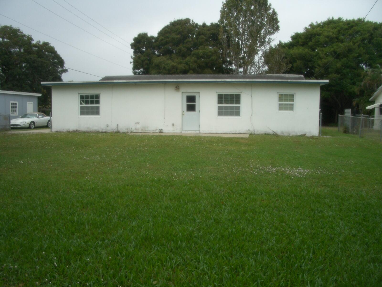 403 Daly Drive Jupiter, FL 33458 - Photo 19 of 27 a front view of house with yard and trees