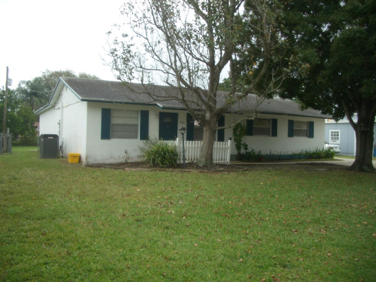 403 Daly Drive Jupiter, FL 33458 - Photo 27 of 27 a front view of house with yard and trees