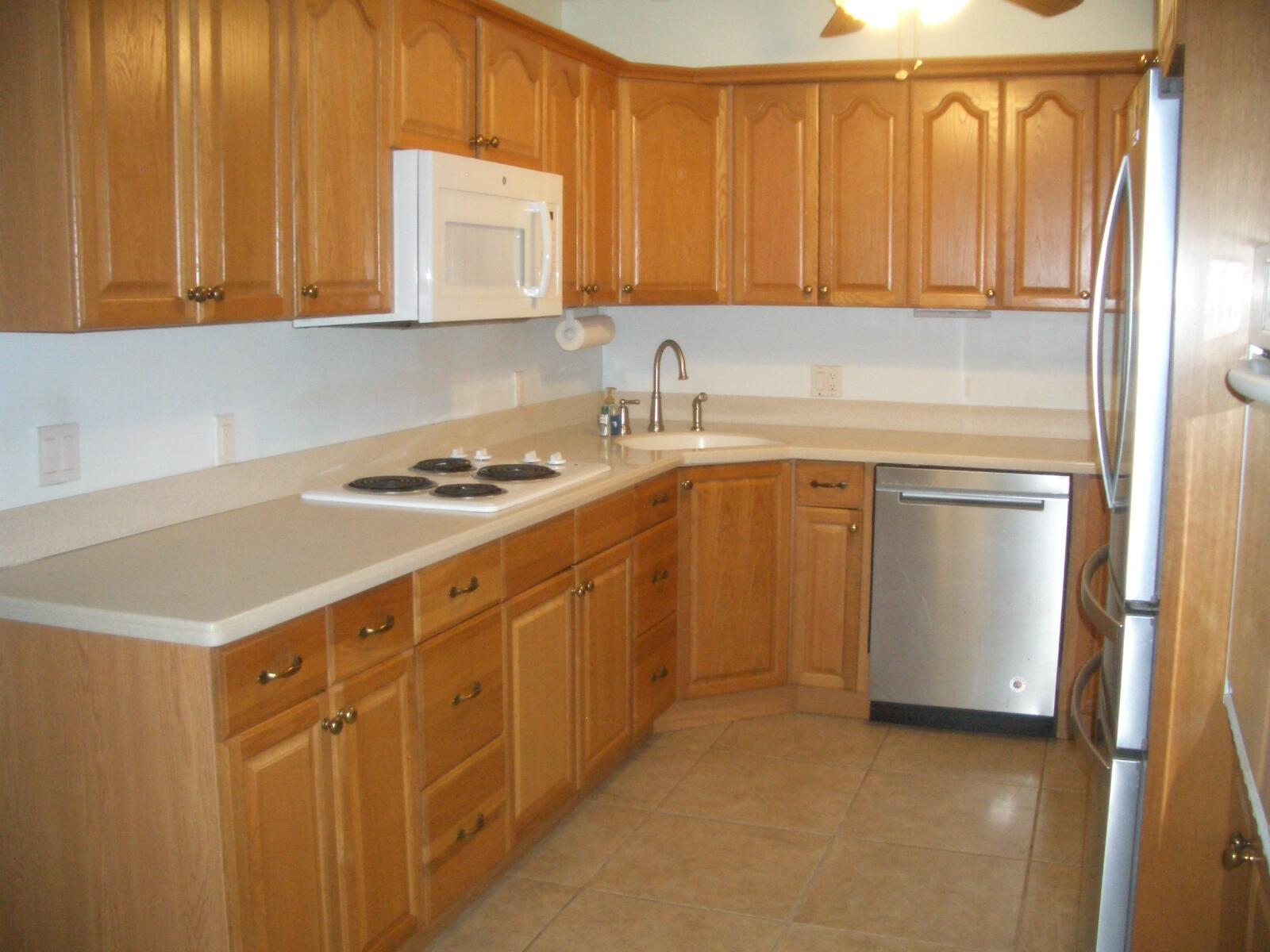 403 Daly Drive Jupiter, FL 33458 - Photo 6 of 27 a kitchen with stainless steel appliances a stove a sink and a refrigerator with cabinets