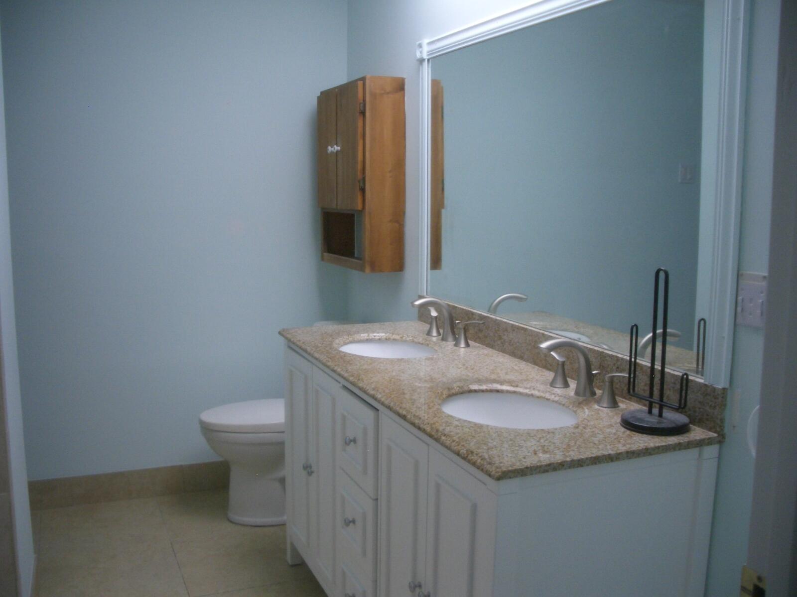 403 Daly Drive Jupiter, FL 33458 - Photo 9 of 27 a bathroom with a granite countertop sink a toilet and a mirror