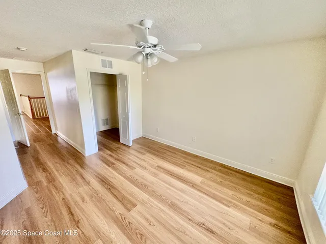 a view of a livingroom with wooden floor and a ceiling fan