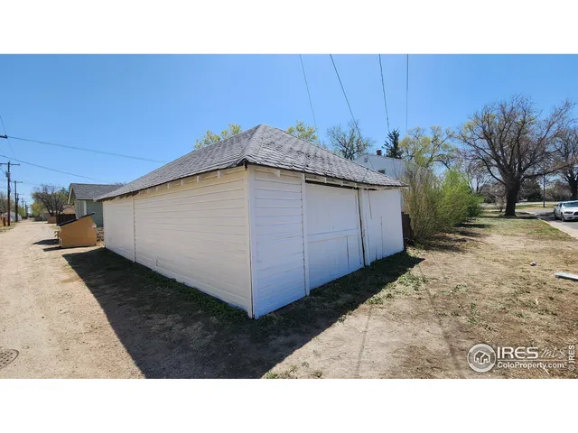 a black and white building with trees in the background