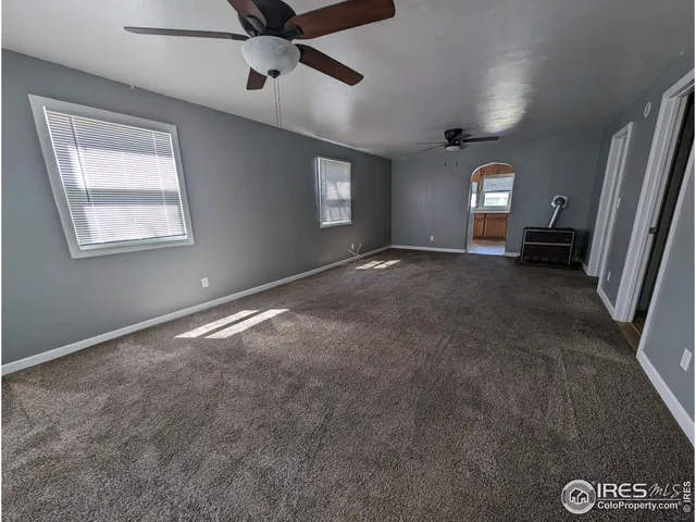 en empty room with windows and ceiling fan