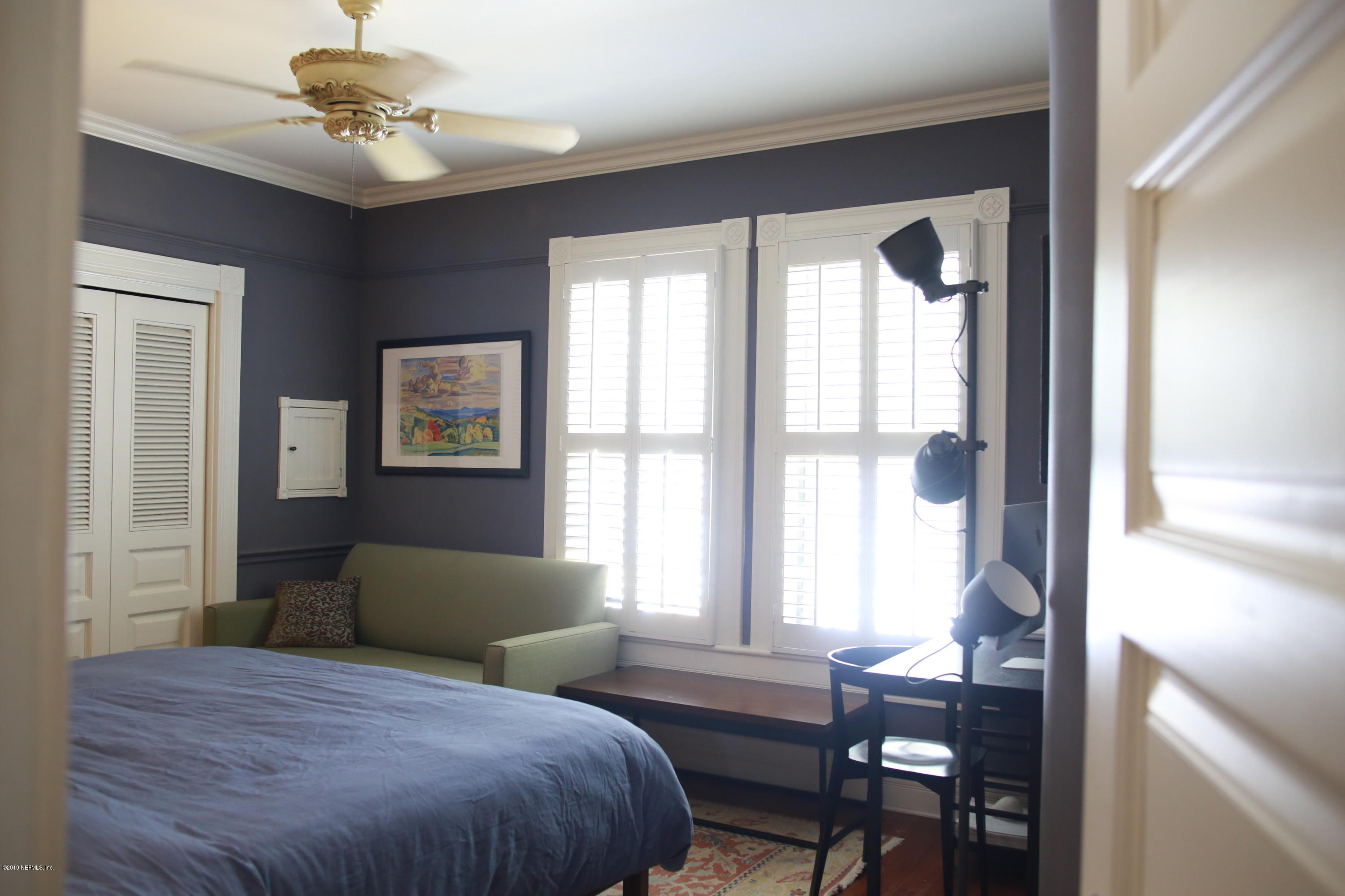 15 Bridge Street St. Augustine, FL 32084 - Photo 20 of 37 a bedroom with a large bed and a chandelier