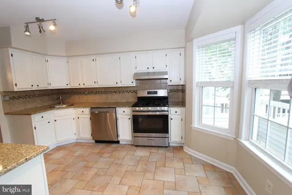 a kitchen with granite countertop a stove a sink and a granite counter tops