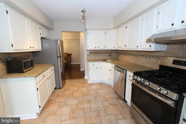 a kitchen with a stove sink and a refrigerator