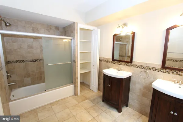 a bathroom with a sink and mirror with bathtub