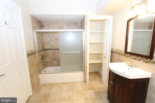 a bathroom with a bathtub sink vanity and mirror
