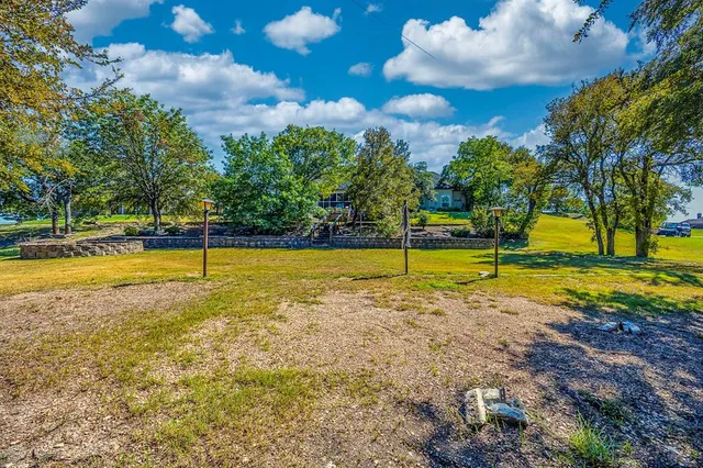 a view of a swimming pool with a yard and palm trees