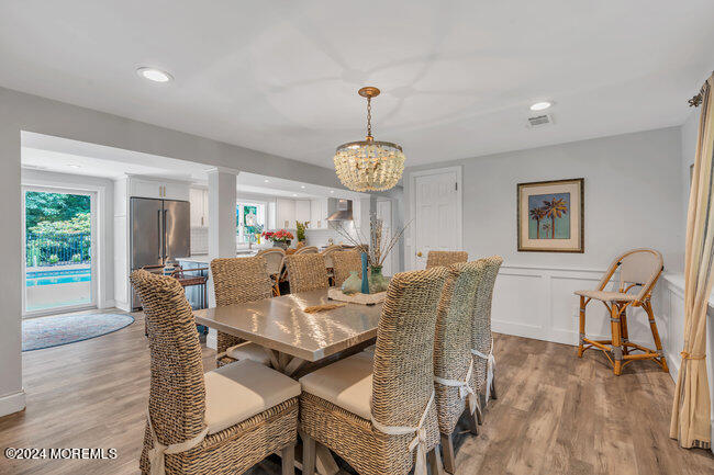 3235 Ridgewood Road Allenwood, NJ 08720 - Photo 21 of 53 a dining room with furniture a chandelier and wooden floor