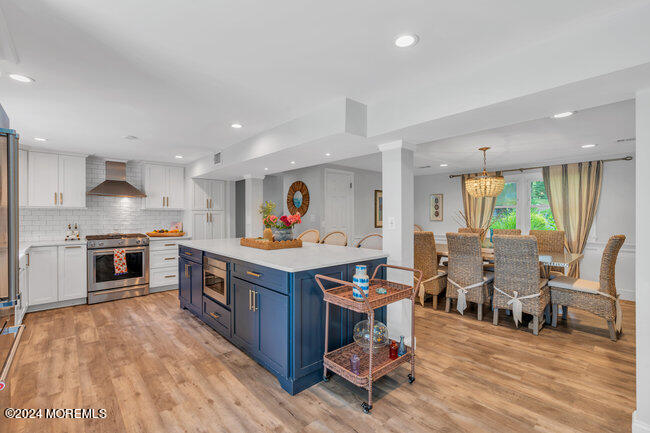 3235 Ridgewood Road Allenwood, NJ 08720 - Photo 24 of 53 a open kitchen with stainless steel appliances granite countertop a stove top oven a sink dishwasher and chairs with wooden floor
