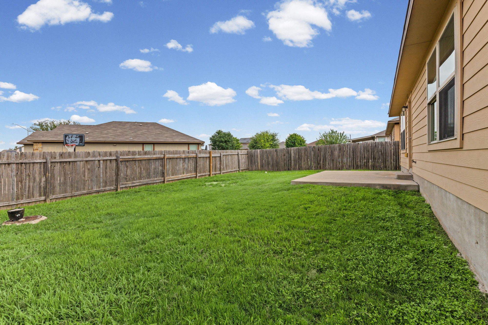 19308 Stokes Lane Pflugerville, TX 78660 - Photo 24 of 27 Expansive backyard featuring a lush lawn, privacy fencing, and a concrete patio