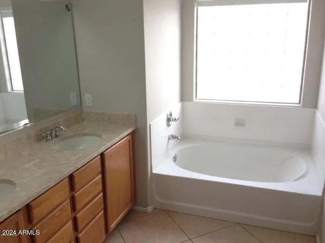 a bathroom with a granite countertop sink and a bathtub