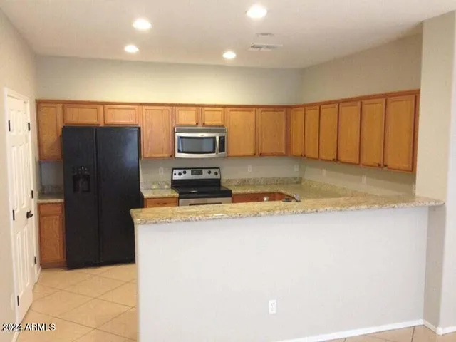 a kitchen with a refrigerator a stove and a microwave