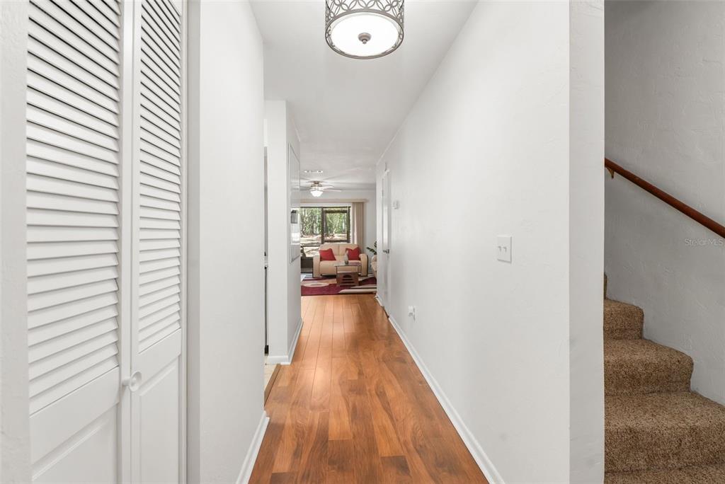 2735 Southwest 35th Place, Unit 903 Gainesville, FL 32608 - Photo 2 of 21 a view of a hallway with wooden floor and furniture