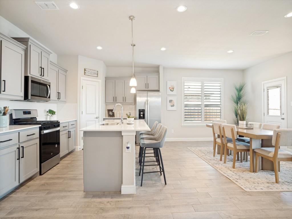 1612 Reed Drive Krum, TX 76249 - Photo 7 of 25 Open-concept kitchen and dining area featuring light wood-finish flooring