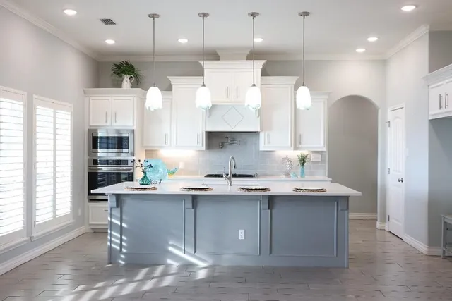 a kitchen with stainless steel appliances granite countertop a sink a stove and a refrigerator