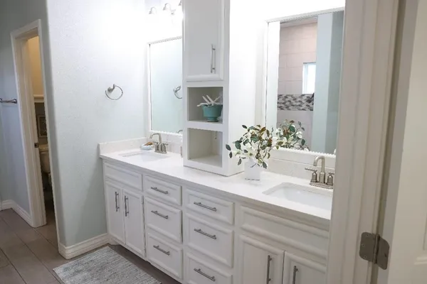 a bathroom with a double vanity sink and a mirror