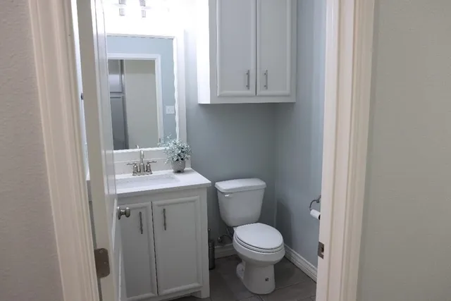 a bathroom with a toilet a sink and cabinets