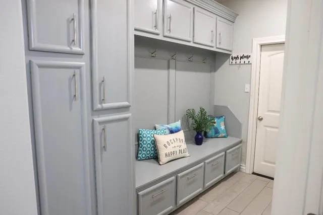 a hallway with white cabinets and wooden floor