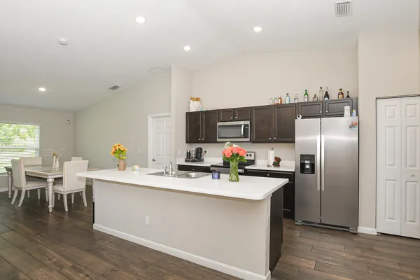 a kitchen with refrigerator and chairs