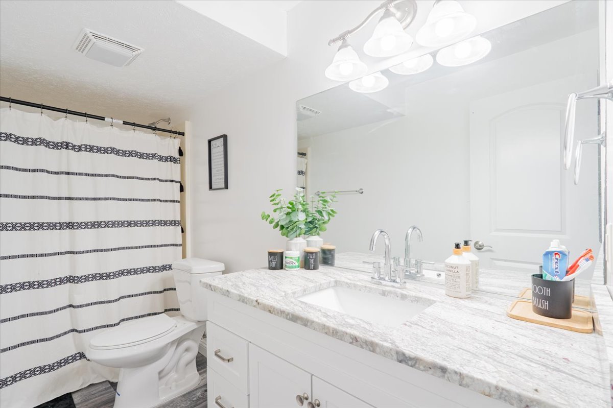 1236 Blue Bill Way Normal, IL 61761 - Photo 28 of 38 a bathroom with a granite countertop sink vanity mirror and toilet