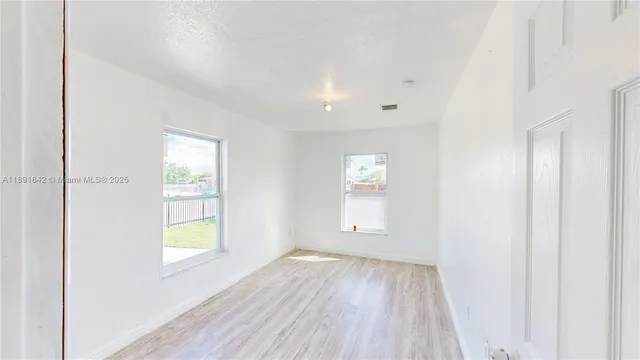 an empty room with windows and closet
